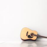 アコースティックギターを床に置いている写真