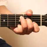 アコースティックギターを演奏しているところ。左手の写真
