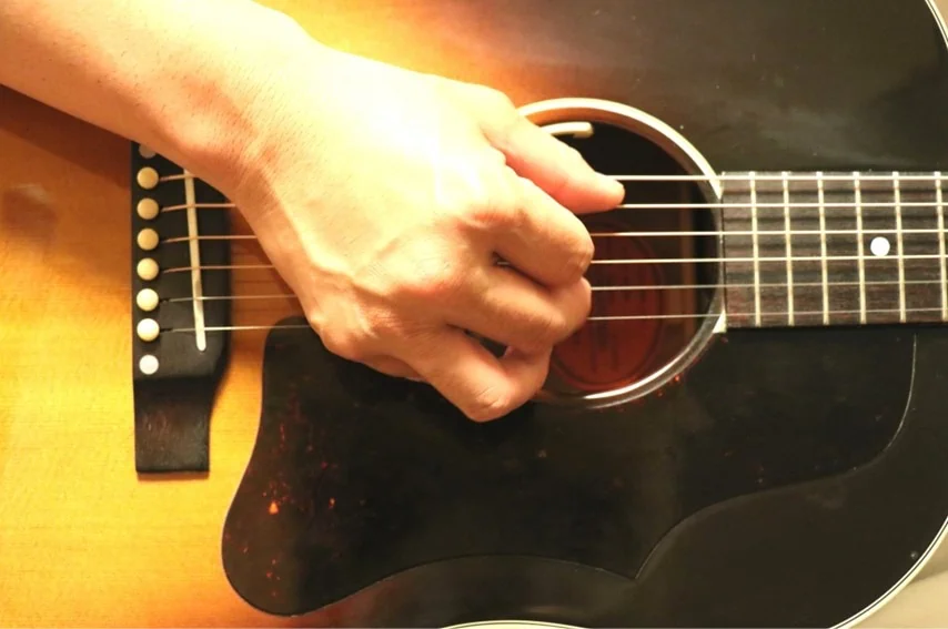 アコースティックギターでアルペジオを弾いているところ